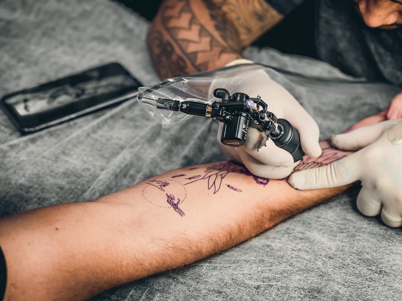 Tatuagem sendo feita com materiais protegidos